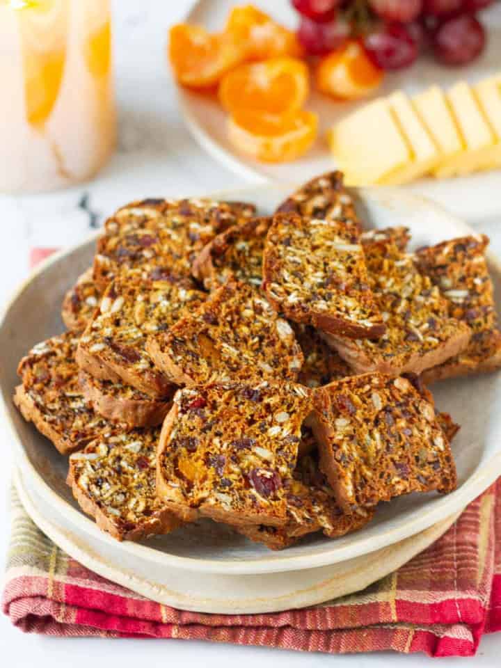 pumpkin cranberry crackers in a bowl on a plaid napkin.