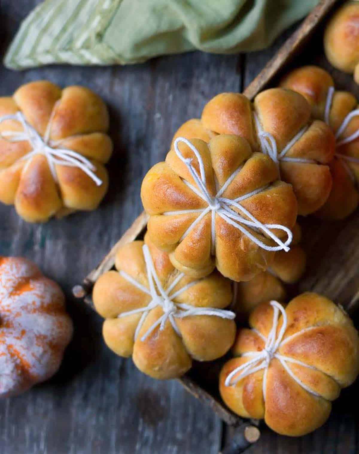 pumpkin bread rolls tied in twine on a surface.