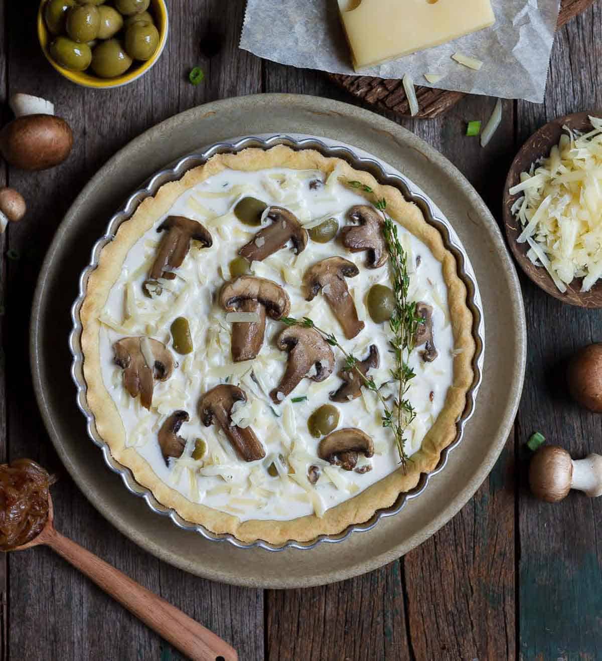 ready to bake mushroom quiche in a pie dish.