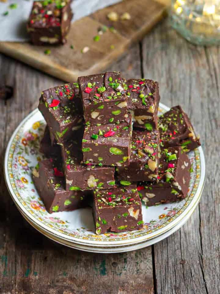 chocolate fudge squares stacked on top of each other on small plate.